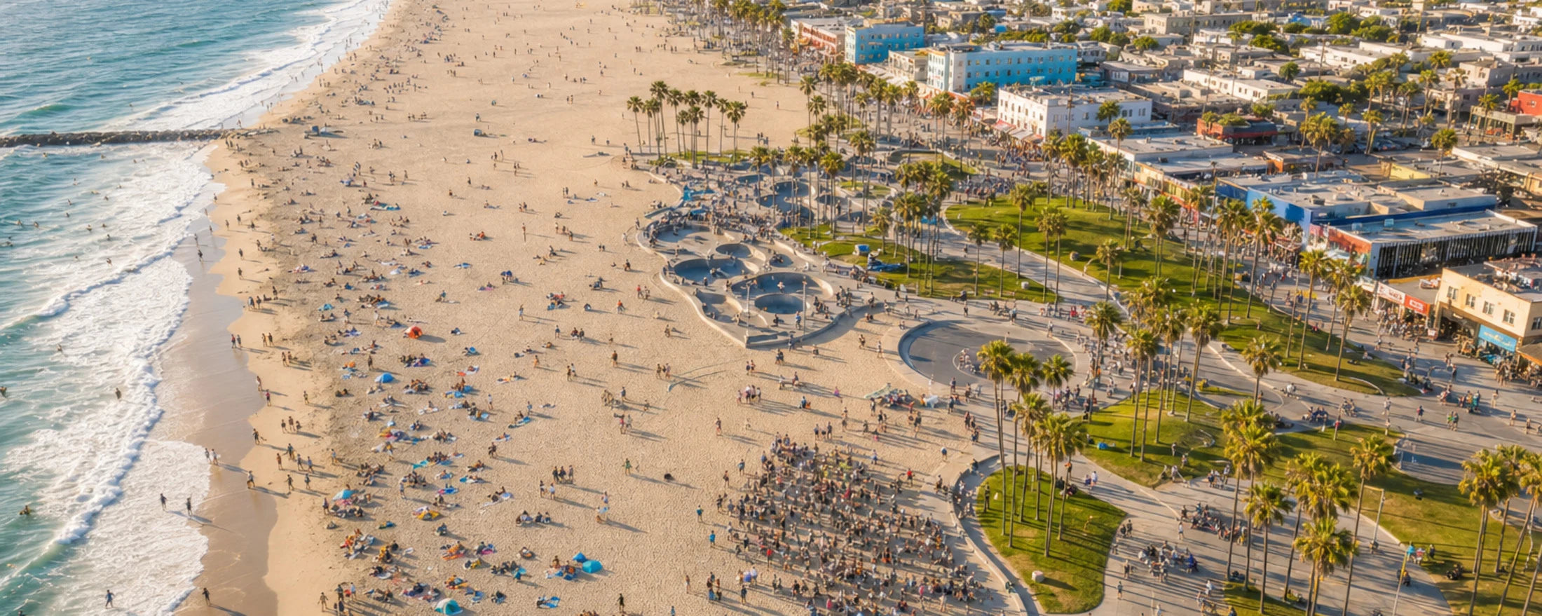 Bright aerial view over the Venice Beach community, skatepark, boardwalk, and shoreline